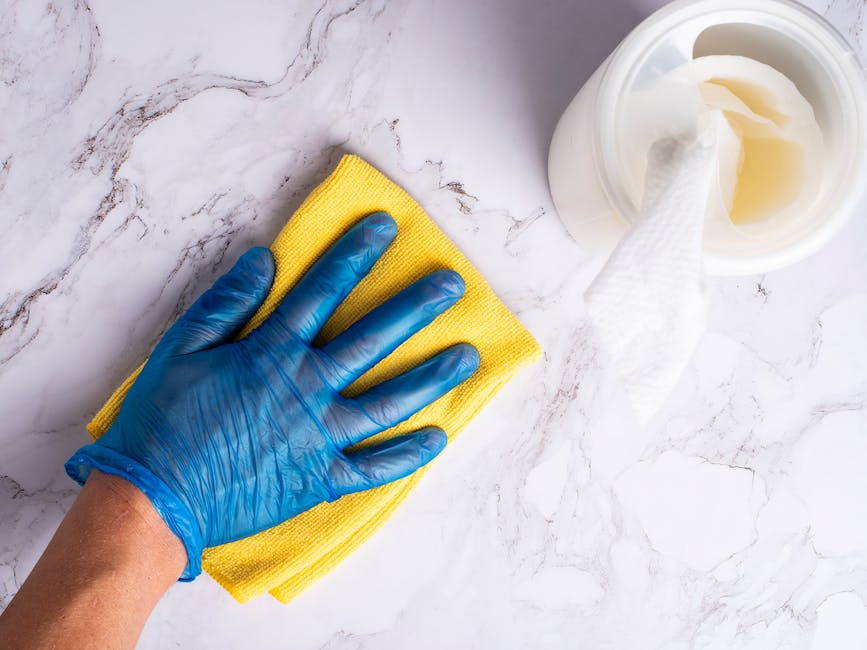 A bottle of OxiClean Toilet Bowl Cleaner with cleaning supplies and a toilet in the background